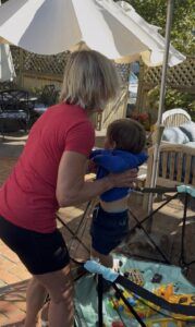 Polli lifting Logan out of playpen